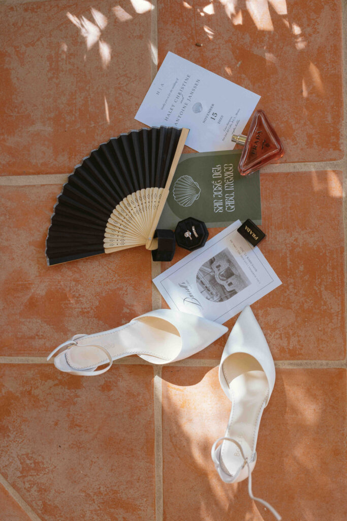 Wedding invitation suite with fan and bridal shoes at a Los Cabos wedding