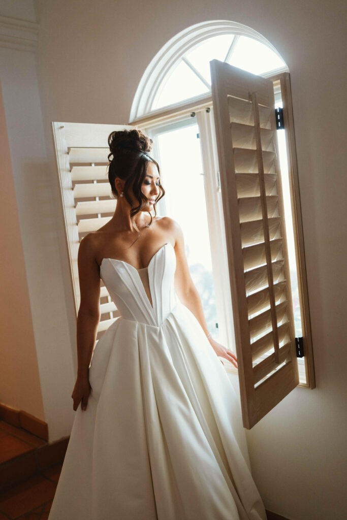 Bride getting ready by a sunlit window at Casa Mariposa Villa

