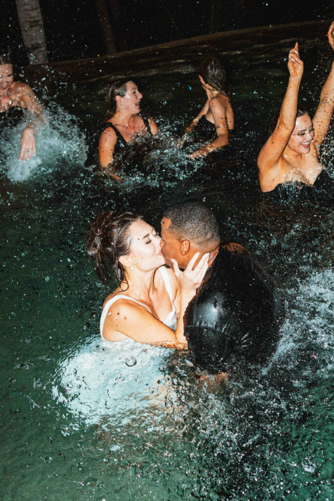 Bride and groom kissing in the pool during their Los Cabos wedding reception
