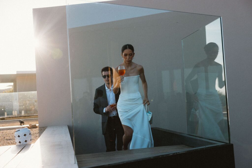 Bride and groom silhouetted in a glass elevator at their Los Cabos welcome party