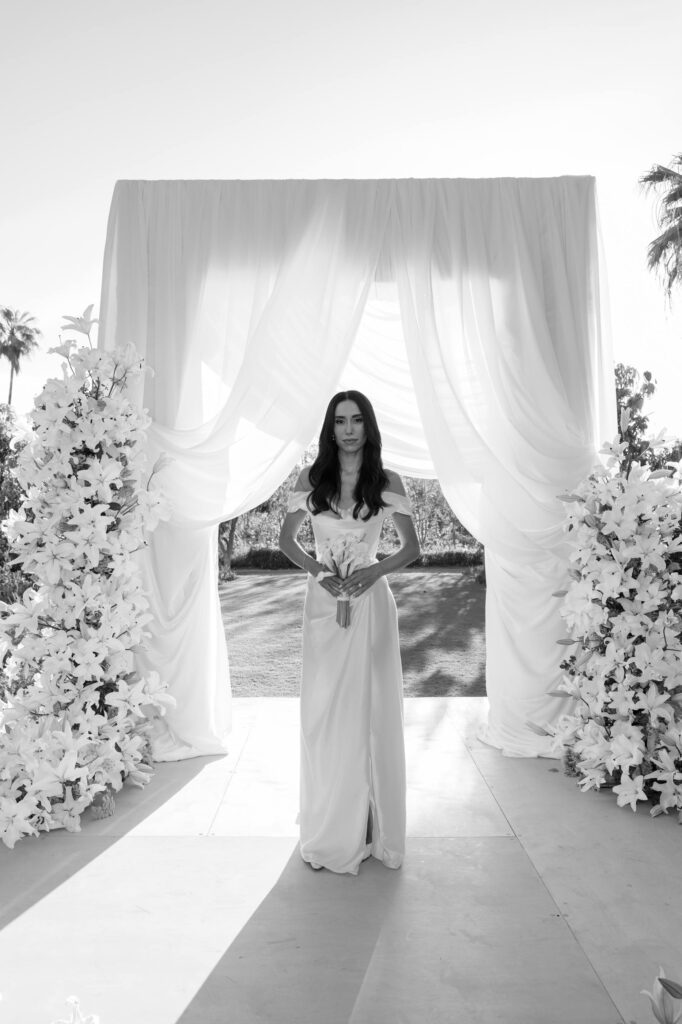 Bride wearing Vivienne Westwood on ceremony site in Flora Farms Cabos Wedding