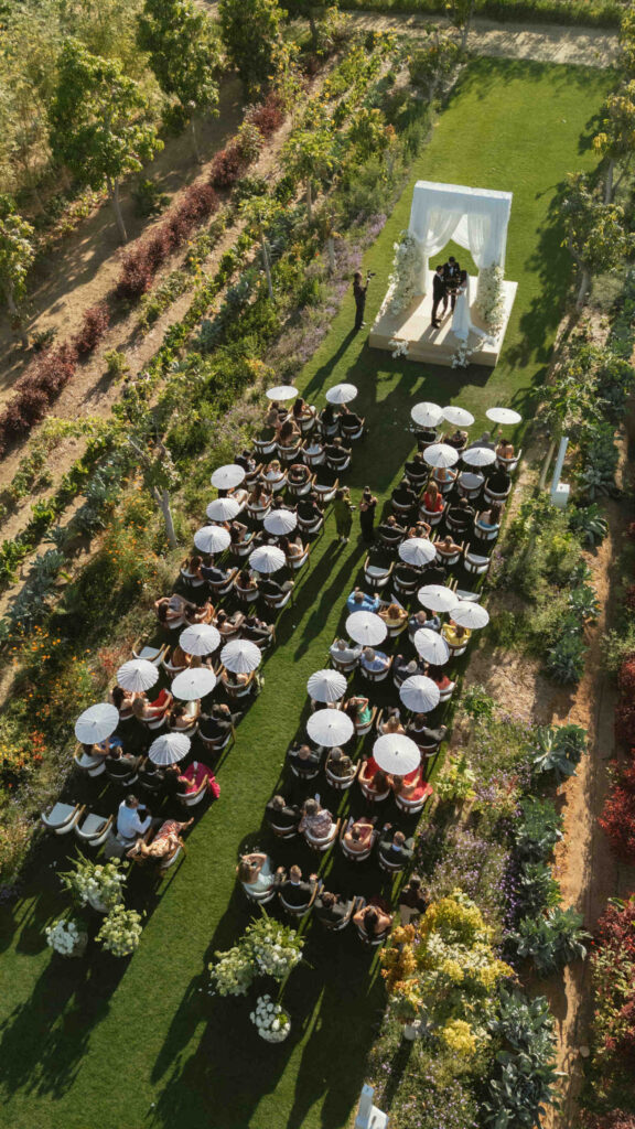 Aerial view of the ivory-draped reception tent and vineyard rows at a Flora Farms wedding